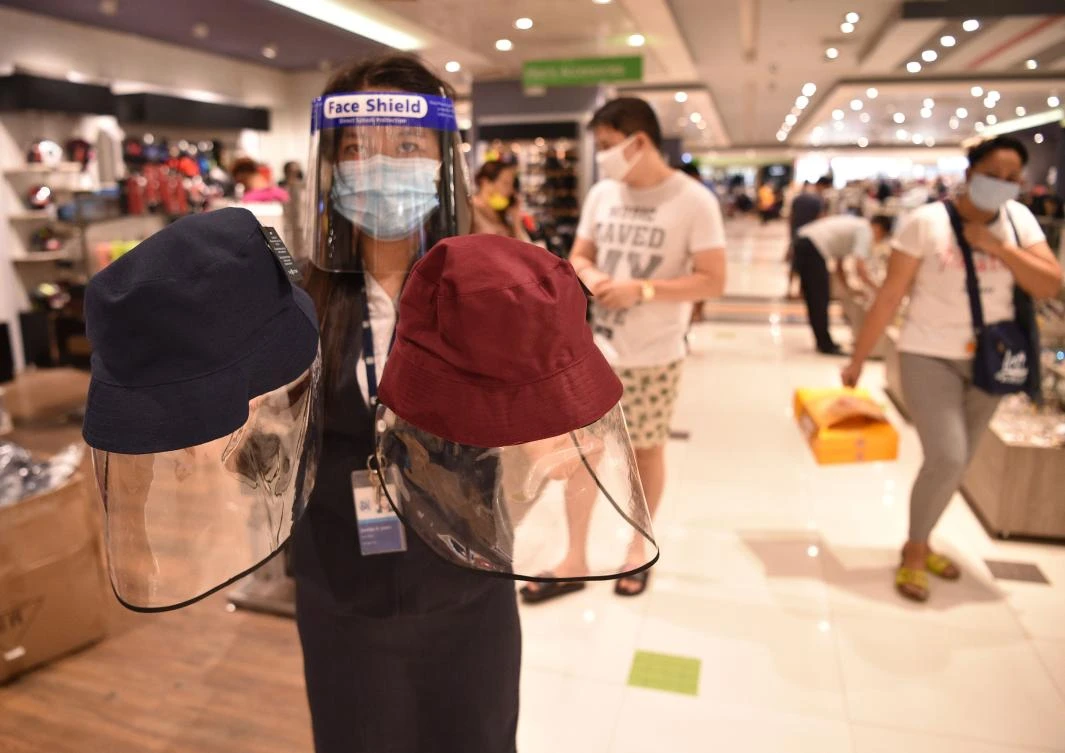 The Philippines on Friday recorded its lowest daily increase in cases in nearly two weeks. Above, a sales staff displays face shields for sale at a retail store in Manila on May 18, 2020. (AFP)