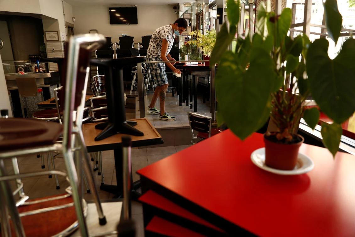 A staff cleans tables at a restaurant in Madrid, Spain on May 22, 2020. Bars and restaurants in the capital will be allowed to reopen terraces and groups of up to 10 people will be allowed to meet too. (Reuters)