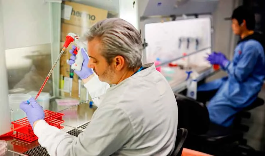 In this file photo taken on February 10, 2020 Doctor Paul McKay, who is working on an vaccine for the 2019-nCoV strain of the novel coronavirus poses for a photograph using a pipette expresses coronavirus onto surface protein to apply cell cultures, in a research lab at Imperial College School of Medicine (ICSM) in London on February 10, 2020. (AFP)