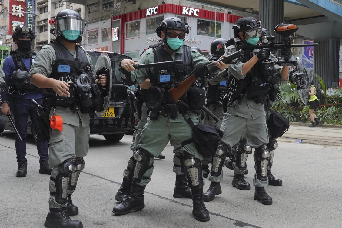 Hong Kong riot police fire tear gas as hundreds of protesters march along a downtown street during a pro-democracy protest against Beijing’s national security legislation on Sunday, May 24, 2020. (AP)