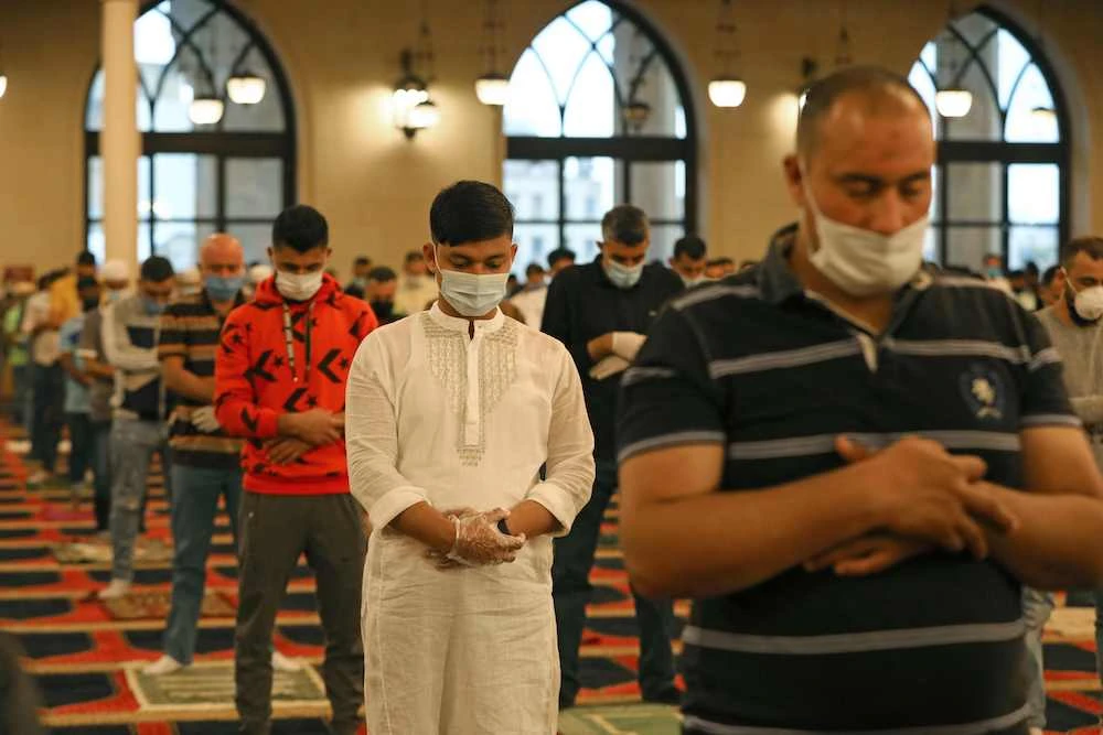 Muslims worshippers take part in a morning prayer to celebrate the Eid Al-Fitr holiday while wearing protective masks and maintaining social distancing due to the COVID-19 pandemic, at Mohammed Al-Amin Mosque in the Lebanese capital Beirut’s downtown district on May 24, 2020. (AFP)