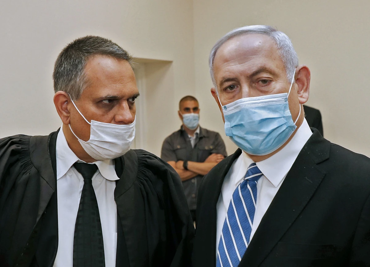 Netanyahu (R) wore a protective face mask during the first day of his corruption trial. (AFP)