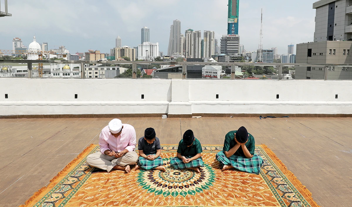 A family pray on the rooftop of their residence in Colombo on Sunday during the Eid Al-Fitr prayers to mark the end of Ramadan. (Reuters)