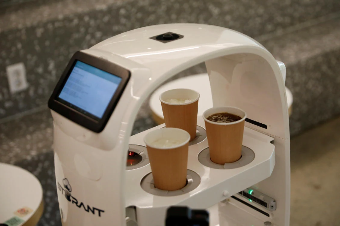 A robot that takes orders, makes coffee and brings the drinks straight to customers is seen in a cafe in Daejeon, South Korea, May 25, 2020. (Reuters/Kim Hong-Ji)