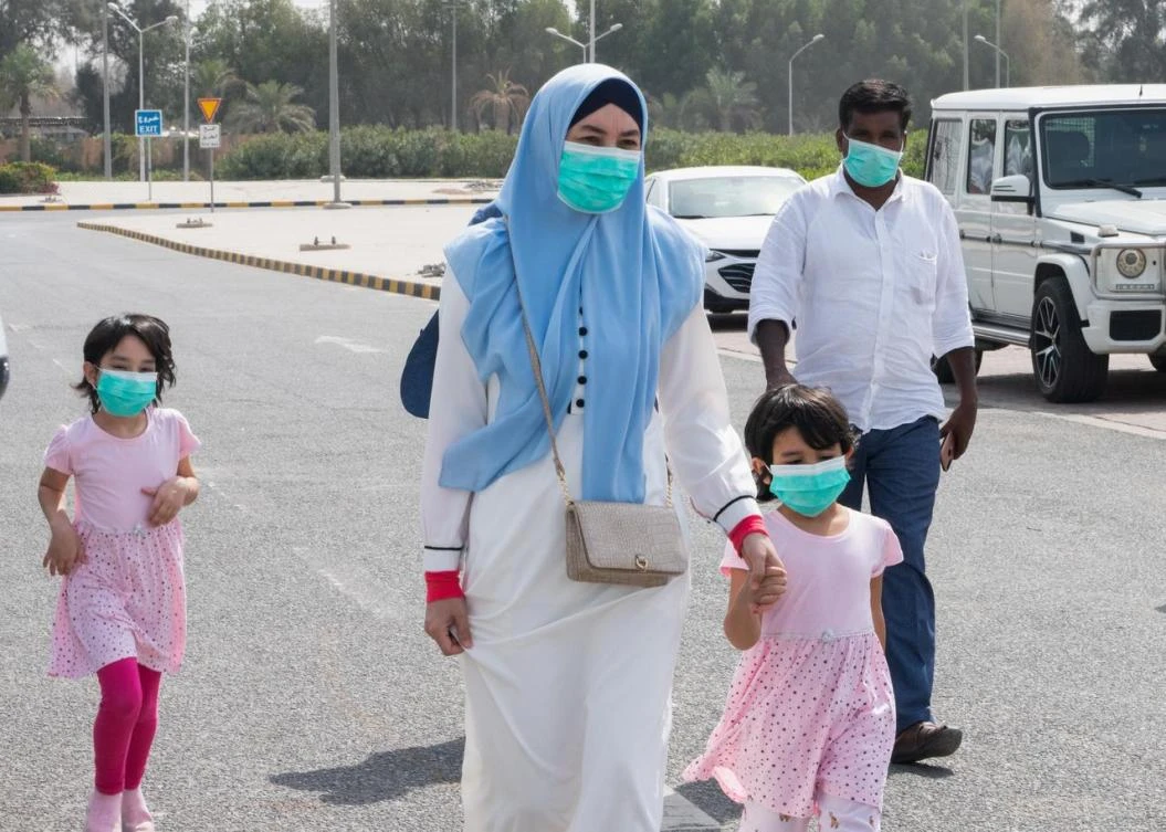 A family wear protective face masks, as they arrive at a coronavirus testing center at the Mishref Fair Grounds in Kuwait city, Kuwait, March 12, 2020. (Reuters)