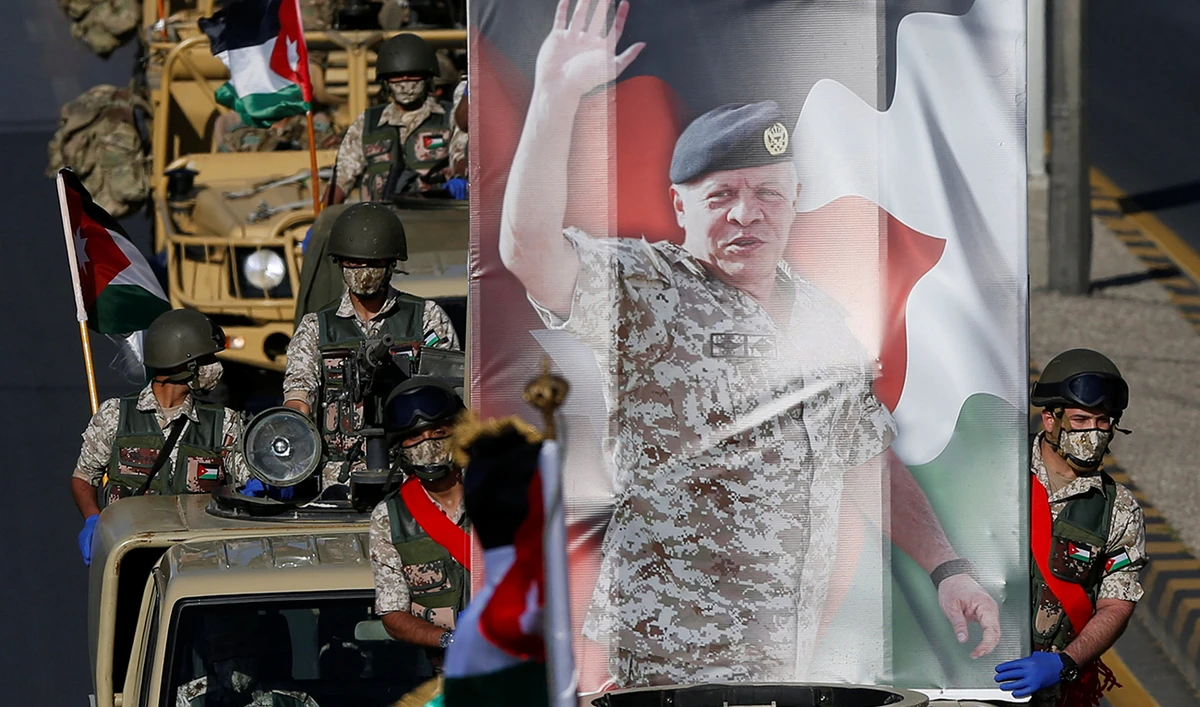 Jordanian troops ride their military vehicles holding a picture of Jordan's King Abdullah during a parade at a ceremony to celebrate the country's 74th Independence Day in Amman. (Reuters)
