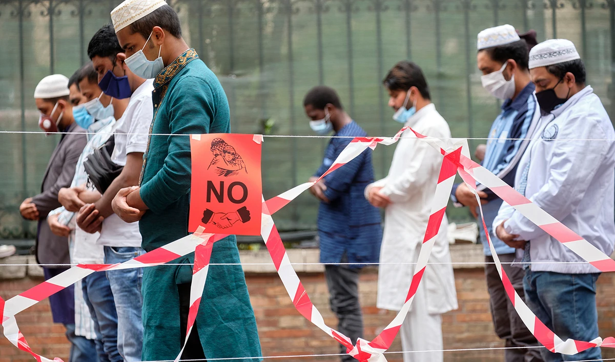 Muslims wearing face masks to prevent the spread of coronavirus attend prayers for Eid Al-Fitr, the feast of breaking the fast which marks the end of Ramadan in Rome's Piazza Vittorio Square. (AP)