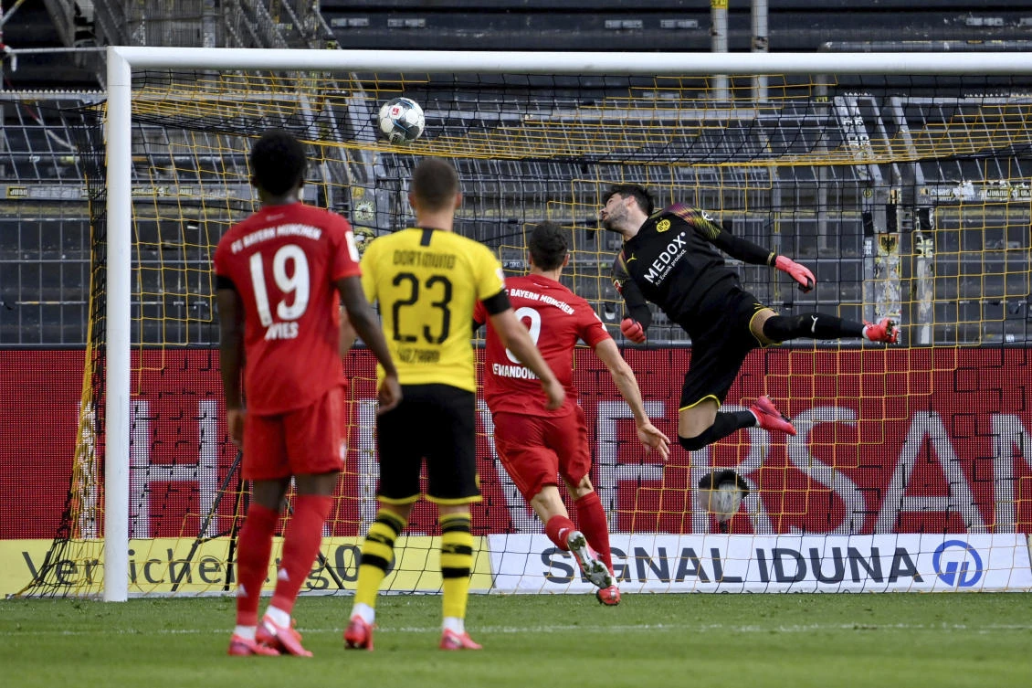 Dortmund's goalkeeper Roman Buerki, right, fails to safe a shot by Munich's Joshua Kimmich during the German Bundesliga match between Borussia Dortmund and Bayern Munich in Dortmund. (AP)