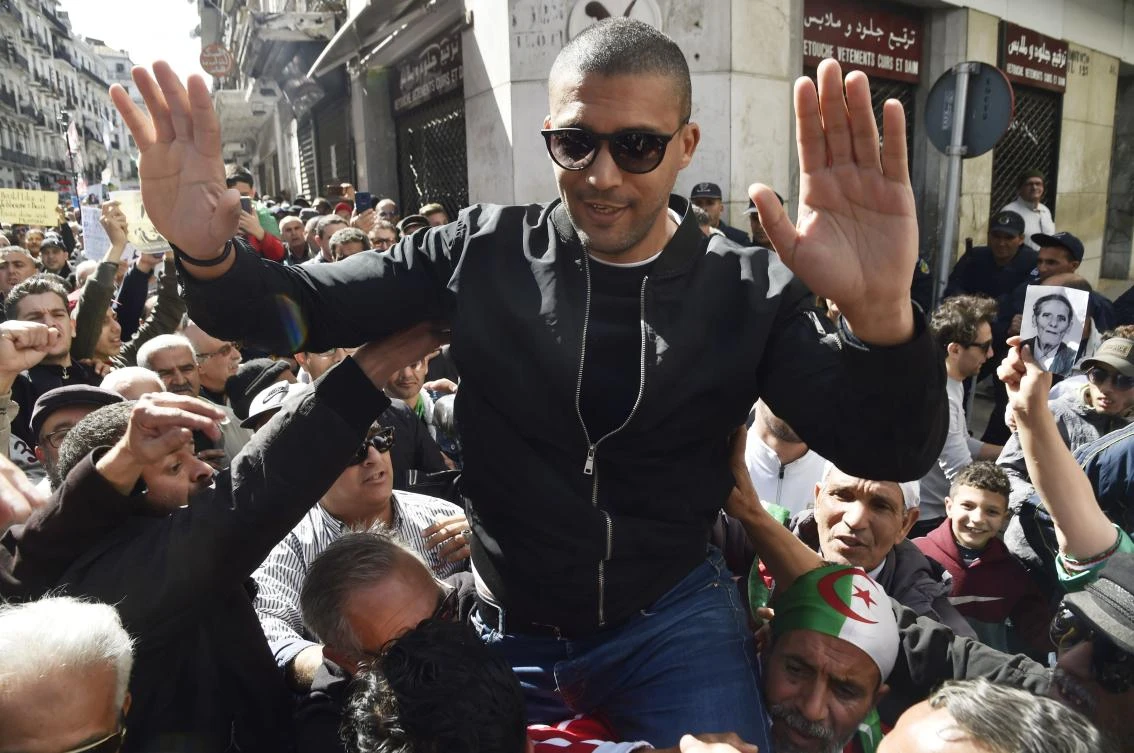 Algerian protesters carry journalist Khaled Drareni on their shoulders in the Algerian capital Algiers, March 6, 2020. (AFP)