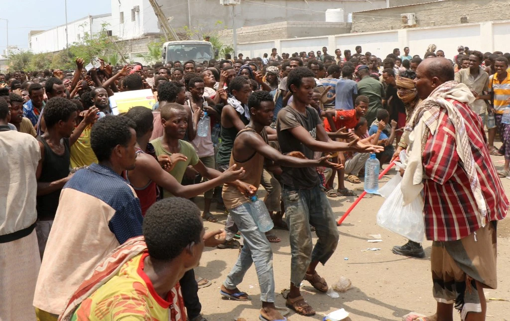 African migrants receive food and water inside a football stadium in the Red Sea port city of Aden in Yemen, on April 23, 2019. (File/AFP)