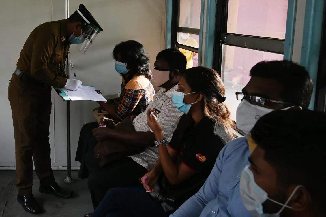 Sri Lanka lifted a shutdown on the capital and a neighboring district, two weeks after easing it in other parts of the nation. Above, commuters on a train in Colombo on May 26, 2020. (AFP)