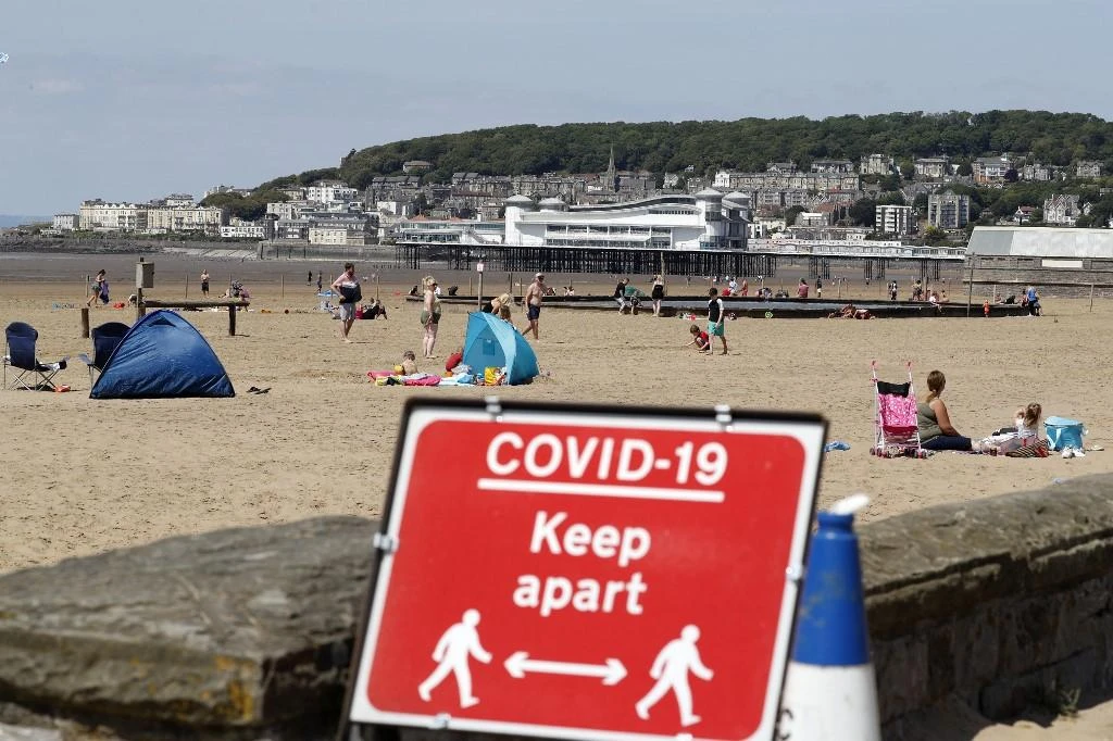 A sign displaying advice on social distancing is displayed at the beach in Weston-super-Mare, south west England on May 27, 2020. (AFP)