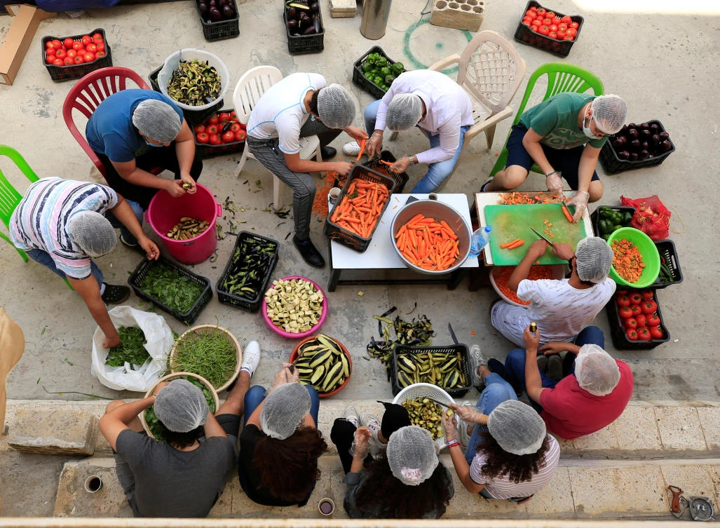 Volunteers prepare food for distribution to people in need in the port city of Sidon, southern Lebanon May 27, 2020. (Reuters)