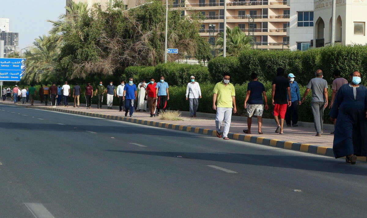 Mask-clad residents take a walk in a neighbourhood of Kuwait city on May 28, 2020, as authorities allowed people to exercise for two hours amid a nationwide lockdown due to the COVID-19 pandemic. (AFP)
