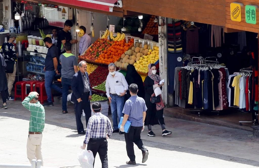 Iranians walk past shops in the capital city of Tehran, on May 26, 2020. (AFP)
