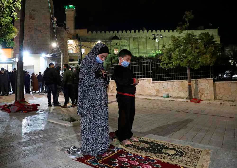 Palestinian worshippers attend dawn prayers outside the Ibrahimi Mosque, also known as the Tomb of the Patriarchs, in the flashpoint city of Hebron, in the occupied West Bank, on May 29, 2020. (AFP)