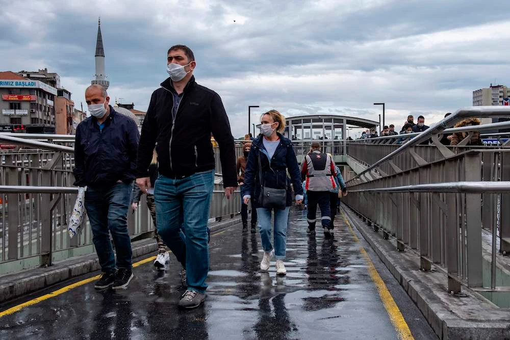 Commuters wearing protective masks at a bus stop in Istanbul on May 27, 2020, following a four-day lockdown imposed by the government to stem the spread of the COVID-19 pandemic. (AFP)