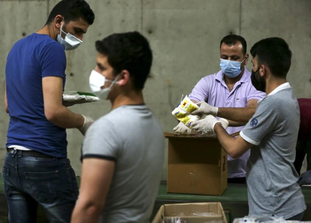 Volunteers fill cartons with food rations in the Lebanese capital Beirut on May 29, 2020. (AFP)