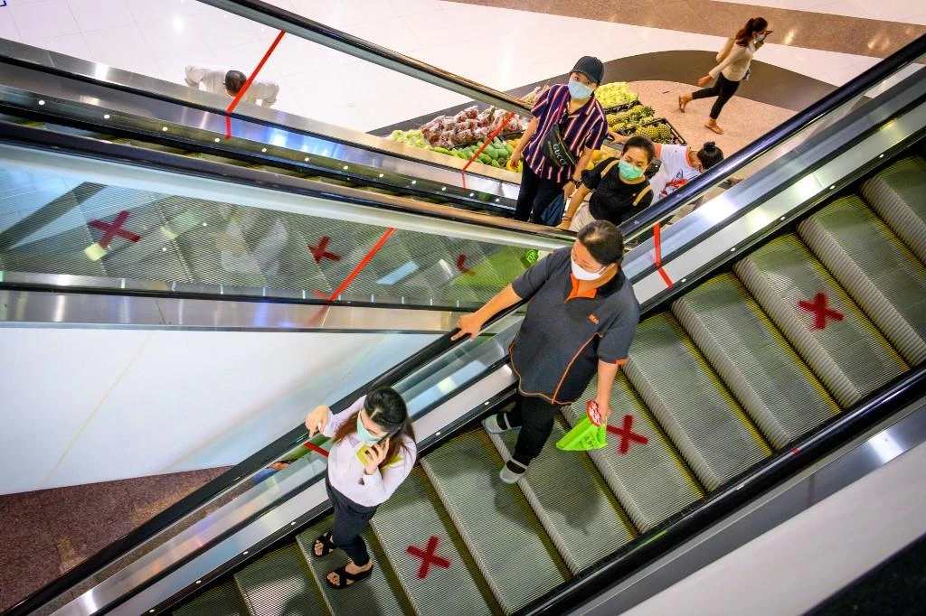 People ride escalators marked for social distancing in a shopping mall in Bangkok. (File/AFP)