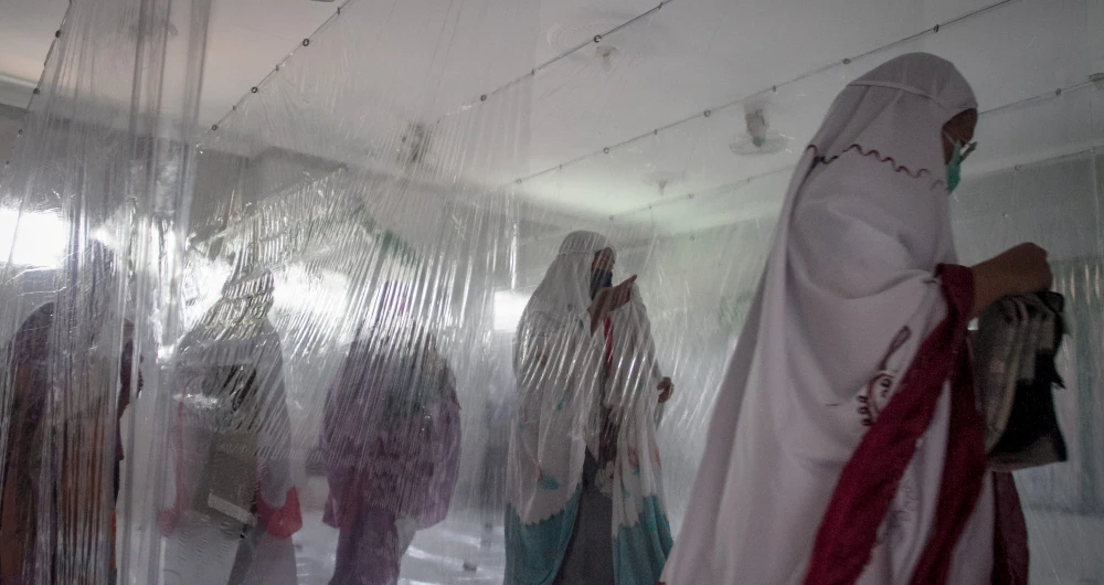 Indonesian Muslims take part in prayers between plastic separation curtains to prevent the spread of the coronavirus disease (COVID-19) in Karanganyar. (Reuters)
