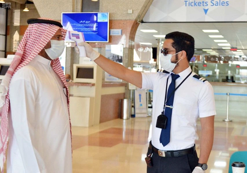 A worker takes the temperature of a passenger at a train station in the Kingdom on May 31, 2020. (SPA)