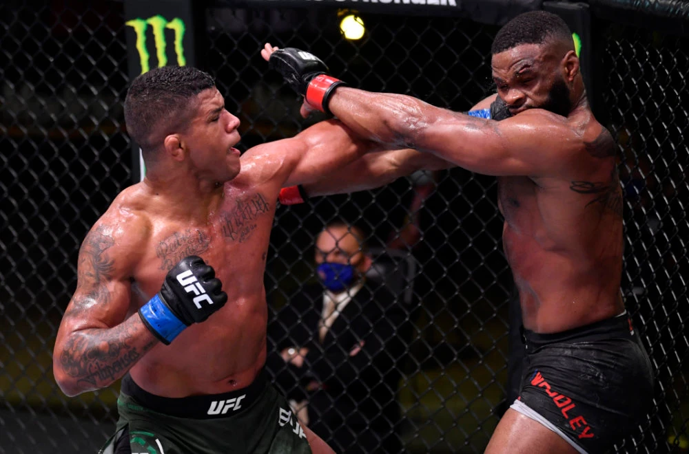 Gilbert Burns of Brazil, left, punches Tyron Woodley in their welterweight fight during UFC Fight Night in Las Vegas. (Reuters)