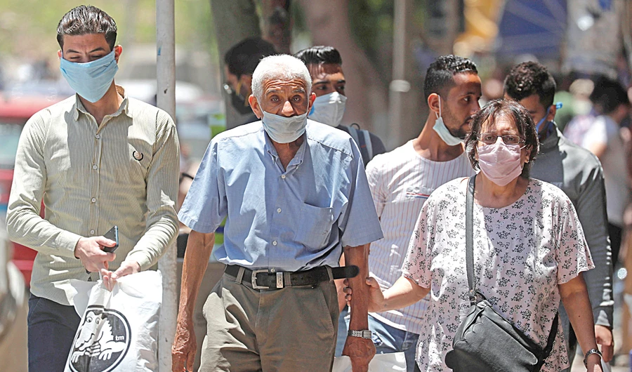 People wearing face masks to prevent the spread of the coronavirus disease (COVID-19) walk in downtown Cairo on Sunday. (Reuters)