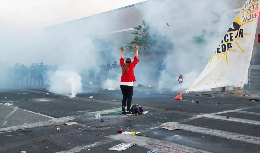 A woman holds her hands aloft as police officers advance during continued protests against the death in Minneapolis police custody of George Floyd, in Minneapolis, Minnesota, on Sunday. (Reuters)