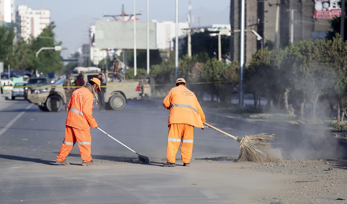 Afghan municipality workers after bomb explosion on a road that targeted a bus carrying local TV station employees in Kabul on Saturday. (AP)