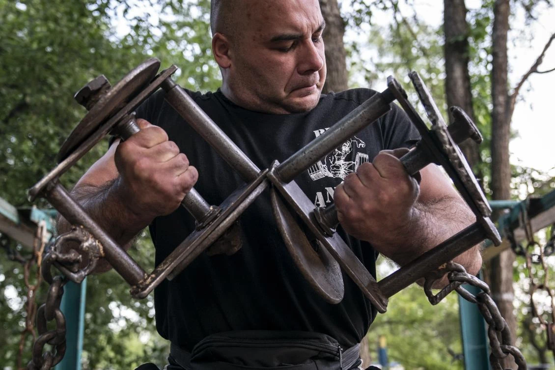 In this photo taken on Sunday, June 7, 2020, a man trains in the outdoors gym on the Dolobetskiy island on the Dnipro River in Kyiv, Ukraine. Relishing an opportunity to do exercise after a long lockdown, hundreds of Kyiv residents flock to an improvised outdoor workout on an island facing the Ukrainian capital. The Kachalka gym on the Dolobetskiy island on the Dnipro river has enjoyed broad popularity ever since it opened in 1966. (AP Photo/Evgeniy Maloletka)