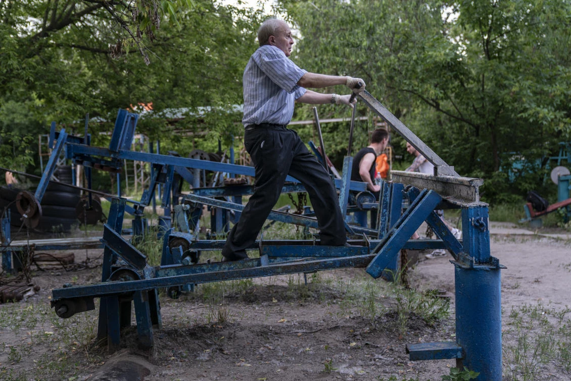 In this photo taken on Monday, June 8, 2020, a man trains in the outdoors gym on the Dolobetskiy island on the Dnipro River in Kyiv, Ukraine. Relishing an opportunity to do exercise after a long lockdown, hundreds of Kyiv residents flock to an improvised outdoor workout on an island facing the Ukrainian capital. The Kachalka gym on the Dolobetskiy island on the Dnipro river has enjoyed broad popularity ever since it opened in 1966. (AP Photo/Evgeniy Maloletka)