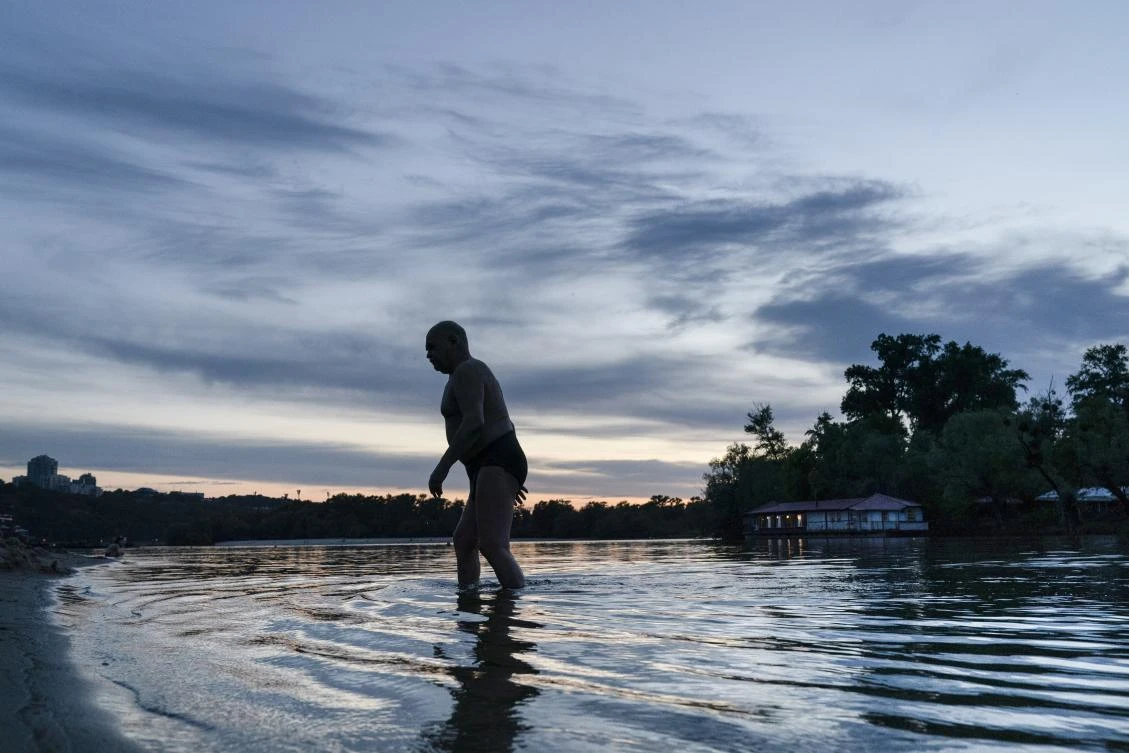 In this photo taken on Monday, June 8, 2020, a man comes out of the water after exercising in the outdoors gym on the Dolobetskiy island on the Dnipro River in Kyiv, Ukraine. Relishing an opportunity to do exercise after a long lockdown, hundreds of Kyiv residents flock to an improvised outdoor workout on an island facing the Ukrainian capital. The Kachalka gym on the Dolobetskiy island on the Dnipro river has enjoyed broad popularity ever since it opened in 1966. (AP Photo/Evgeniy Maloletka)