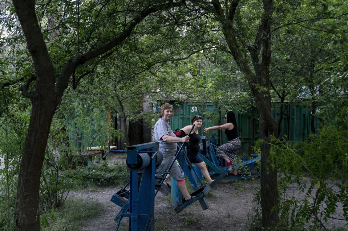 In this photo taken on Monday, June 8, 2020, women train in the outdoors gym on the Dolobetskiy island on the Dnipro River in Kyiv, Ukraine. Relishing an opportunity to do exercise after a long lockdown, hundreds of Kyiv residents flock to an improvised outdoor workout on an island facing the Ukrainian capital. The Kachalka gym on the Dolobetskiy island on the Dnipro river has enjoyed broad popularity ever since it opened in 1966. (AP Photo/Evgeniy Maloletka)