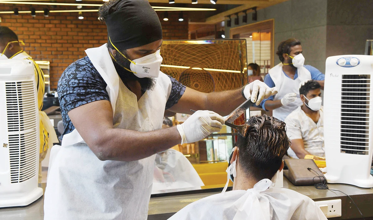A hairdresser gets to ply his trade again in Chennai after the government eased the nationwide lockdown on Monday. (AFP)