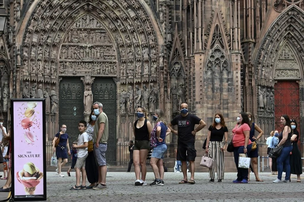 People wearing protective face masks while queuing at an ice-cream shop in Strasbourg, eastern France. (File/AFP)
