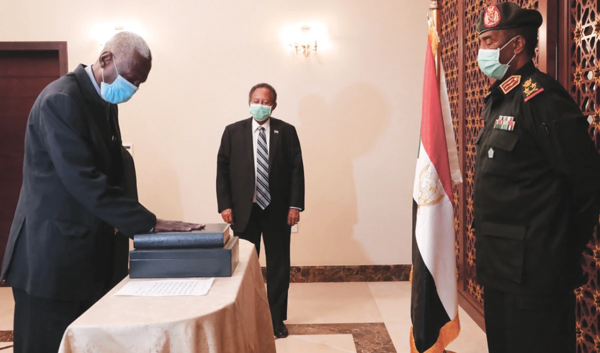 Maj. Gen. Yassin Ibrahim Yassin, left, takes the oath as minister of defense in the presence of Prime Minister Abdalla Hamdok, center, in Khartoum. (AP)