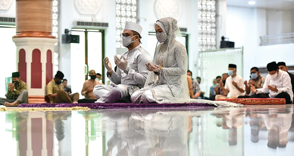 A couple wearing face masks amid the coronavirus pandemic attend their wedding ceremony at a mosque in Banda Aceh. (AFP)