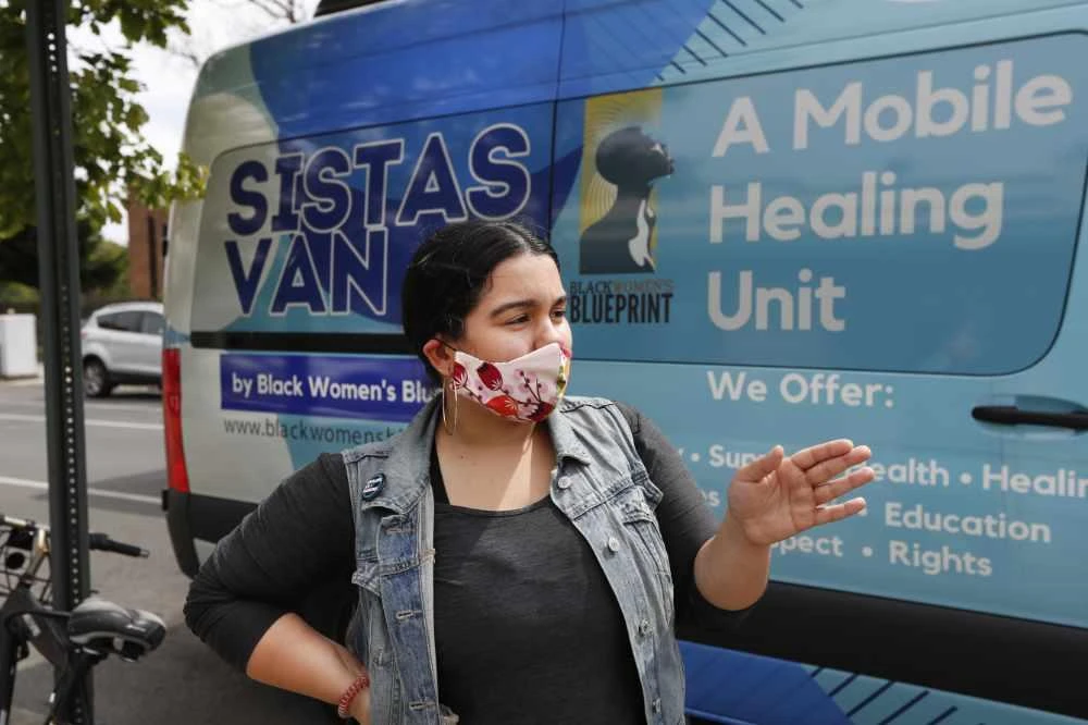 Sistas Van driver Denise Rodriguez pauses in front of the van she uses to pick up and drop off supplies for those in need of help amid the coronavirus outbreak on May 19, 2020, in New York. (AP File Photo/Kathy Willens)