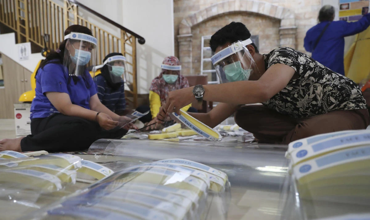 Local community health center workers assemble face shields in the off time to be distributed to co-workers as a precaution against the spread of the coronavirus in Jakarta, Indonesia Thursday, June 4, 2020. (AP)