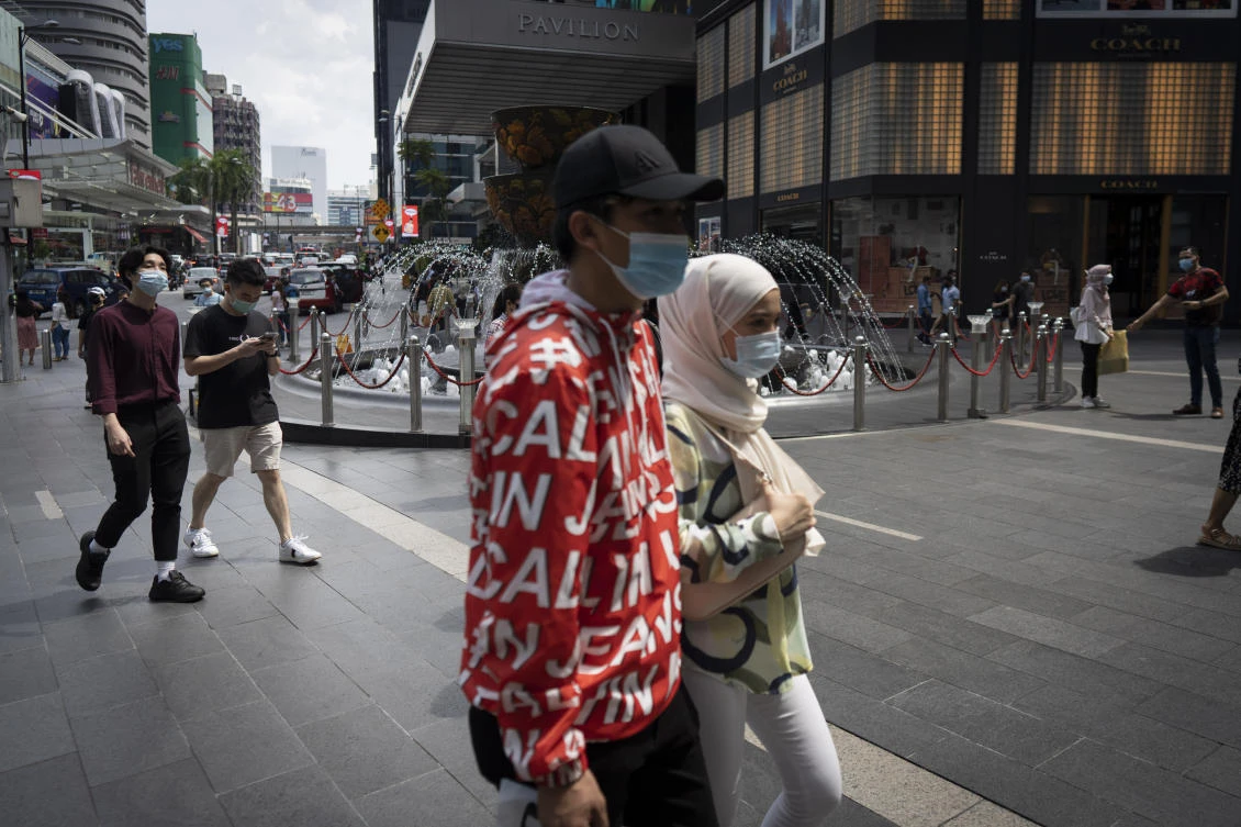 Shoppers wearing face mask walks at a shopping mall in downtown Kuala Lumpur, Malaysia, on Sunday, June 7, 2020. (AP)