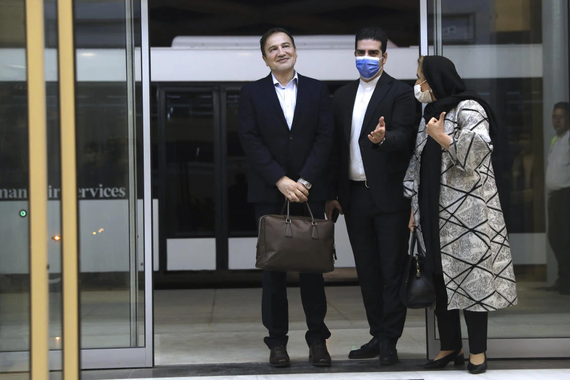 Iranian doctor based in Florida Majid Taheri, left, is welcomed by an Iranian Foreign Ministry official as his wife stands at right, upon arrival at Tehran's Imam Khomeini Airport from the U.S. after being part of a swap that saw a U.S. Navy veteran held by Iran return to America, Monday, June 8, 2020. (AP)