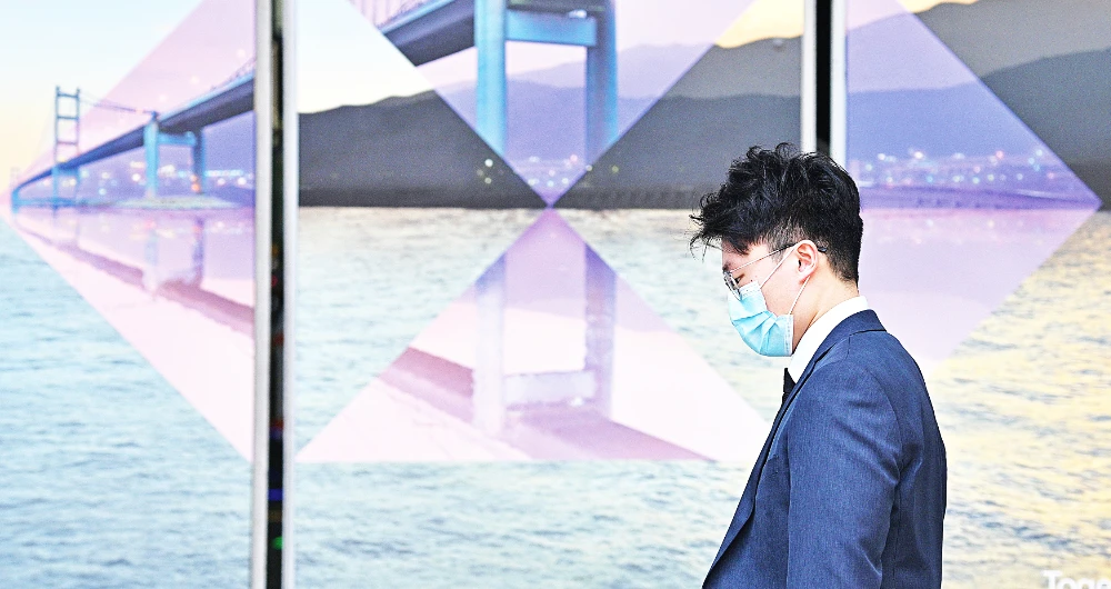 An employee walks past an HSBC logo outside the bank’s headquarters in Hong Kong. (AFP)