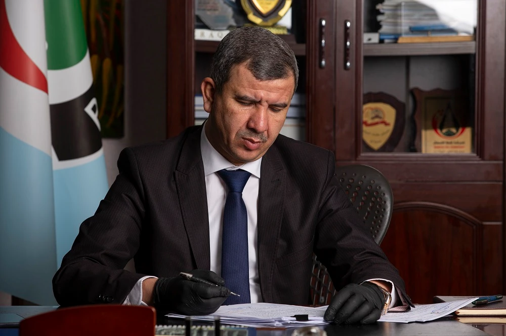 Newly-appointed Iraqi Minister of Oil Ihsan Jabbar reads documents at the Basra Oil Company in Iraq's southern port city, on May 9, 2020. (File/AFP)