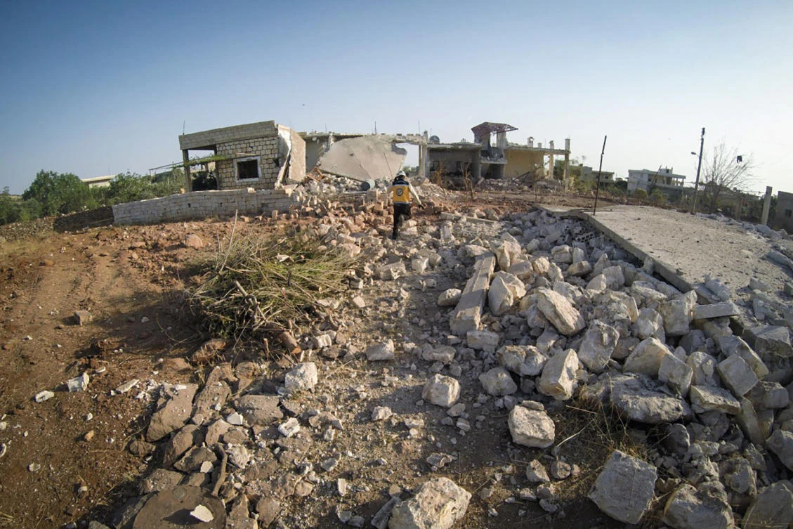 A Syrian White Helmet civil defense worker walks amid the rubble of houses hit by airstrikes, in Balyoun village, southern Idlib province, Syria, Tuesday, June 9, 2020. (AP Photo)