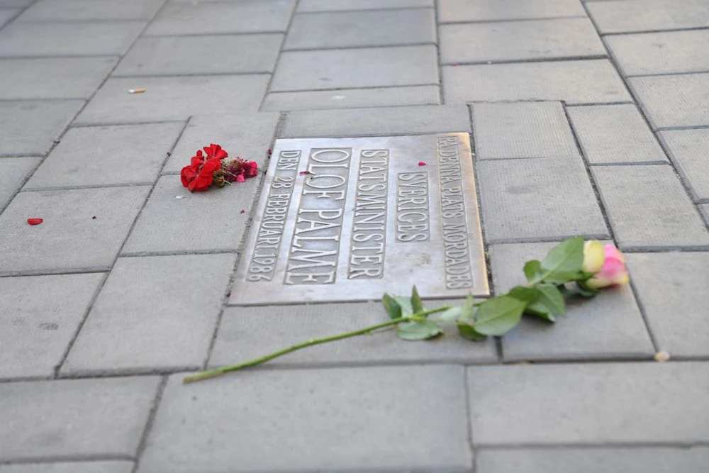 Flowers are placed next to a plaque on Sveavägen in Stockholm on June 10, 2020, at the site where Sweden’s Prime minister Olof Palme was murdered in March 1986. (AFP/TT News Agency)