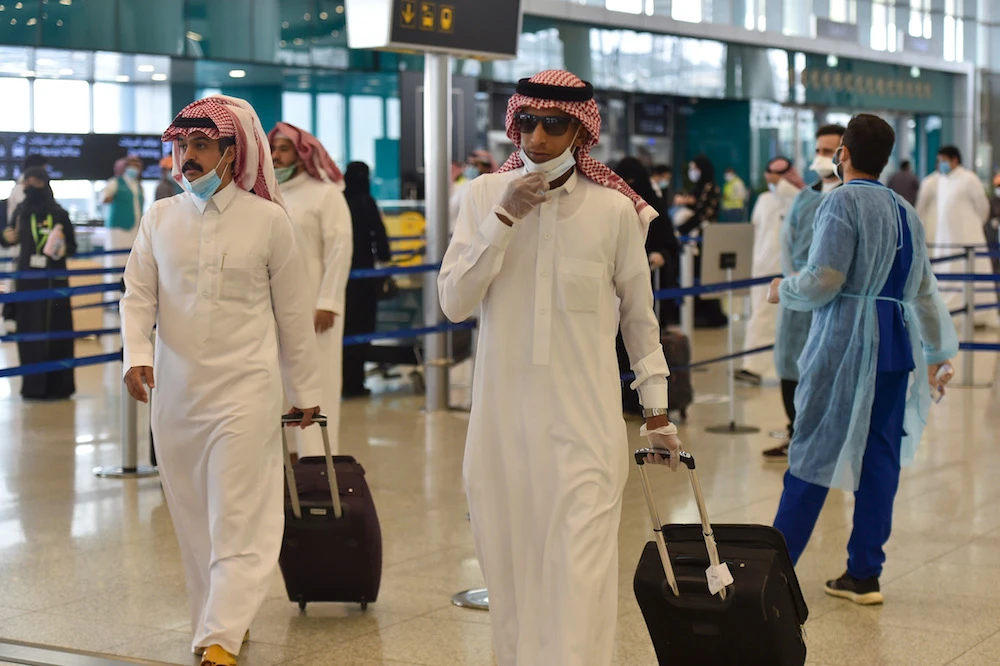Saudi passengers queue for a temperature check at terminal 5 in the King Fahad International Airport, designated for domestic flights, in the capital Riyadh on May 31, 2020, after authorities lifted the ban on flights within the country. (AFP/File Photo)