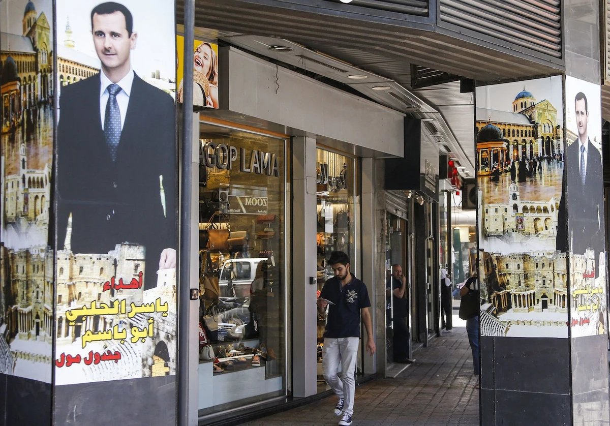 Pillars are adorned with posters showing Syrian President Bashar Al-Assad superimposed over Damascus' historic Umayyad mosque, in Damascus on June 10, 2020. (AFP)