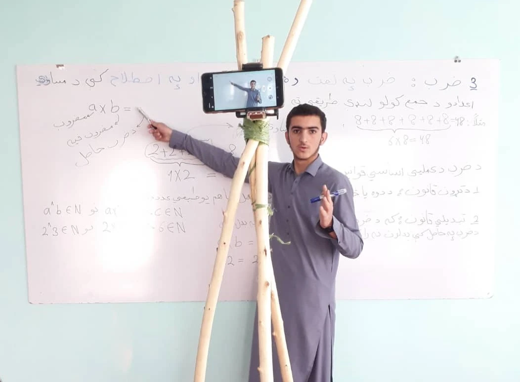 Shabir Ahmad, a 17-year-old student, records lessons before uploading them online for students whose schools have been shut because of the COVID-19 lockdown in Afghanistan. (Supplied)