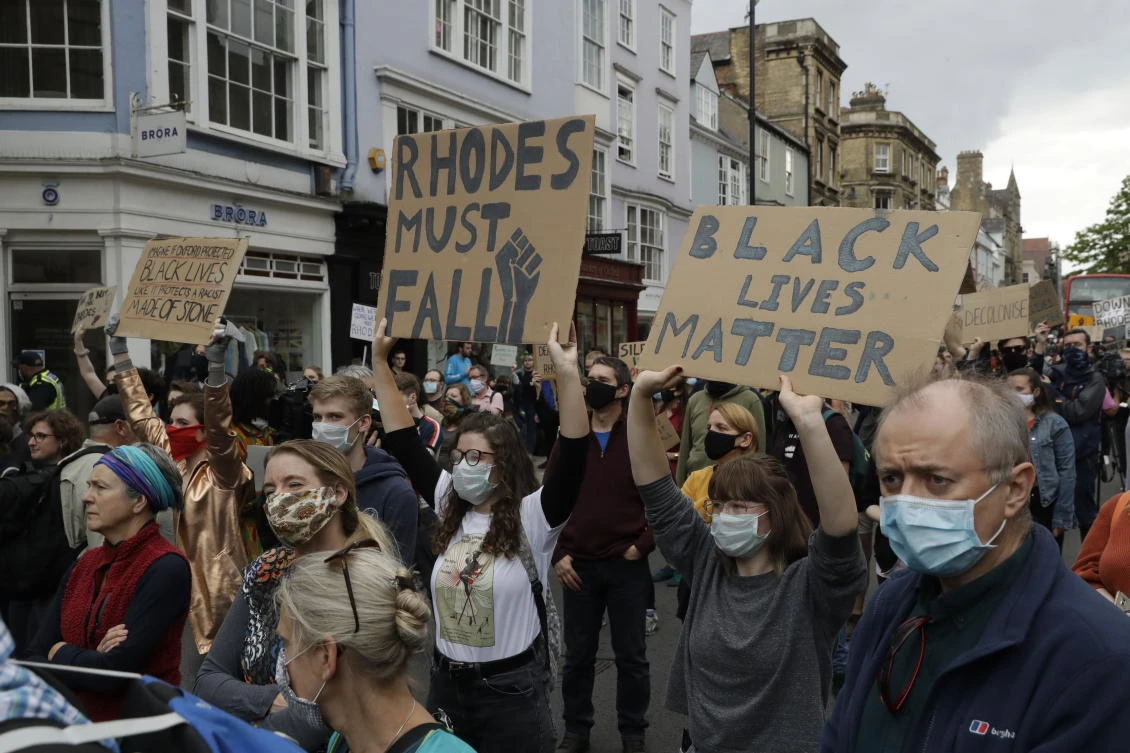 Supporters of the Rhodes Must Fall group, wearing protective masks against the spread of coronavirus, participate in a protest calling for the removal of a statue of Cecil Rhodes. (AP)