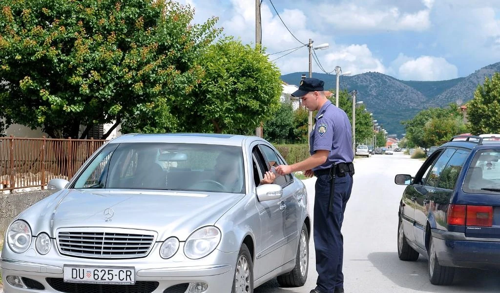 A Croatian border police officer checks the ID of a driver along the border between Croatia and Montenegro. (File/AFP)